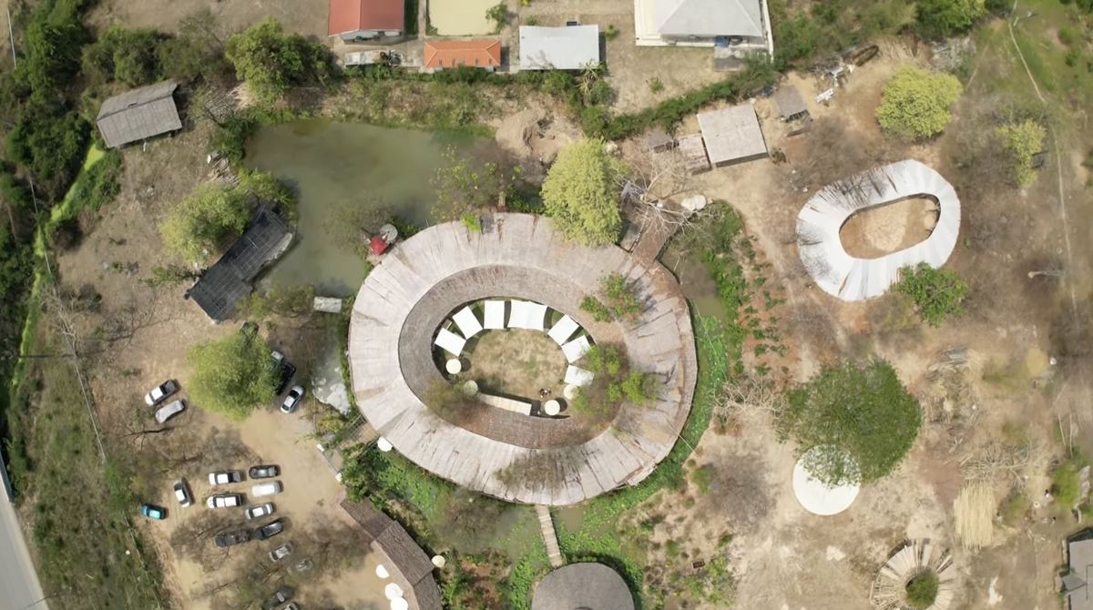 SangGaDee Space from above: the round bamboo market roof around a lawn, the pond and the gardens